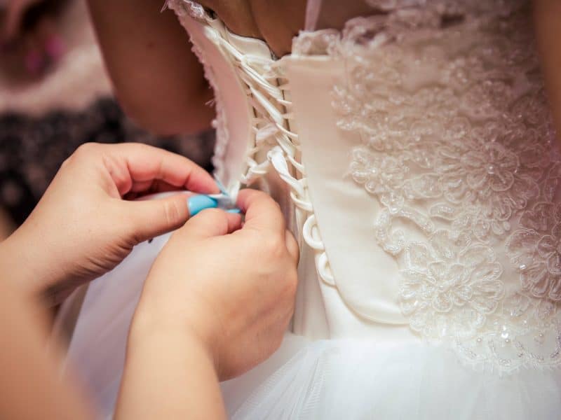 photo-of-woman-fixing-the-wedding-gown