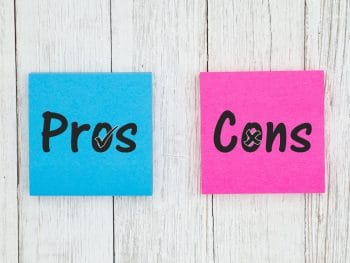 Pros and Cons on two sticky notes on white wood