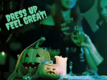 women dressed in halloween costume are in the background. The foreground shows a display of two pumpkins and a candle. Text reads 'dress up, feel great'.