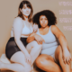 two plus size women in shapewear are siting facing the camera with their limbs entwined. Text reads "versatile shaping is what we want".